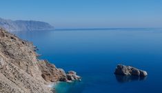 an ocean view with rocks and blue water