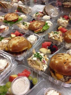 several plastic containers filled with different types of sandwiches and other food on top of a table