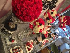 a table topped with lots of red and white flowers on top of a silver counter