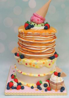 a stack of pancakes with ice cream and strawberries on top is decorated like an ice cream cone