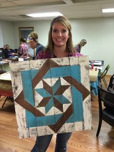 a woman holding up a wooden sign with an image of a star in the center