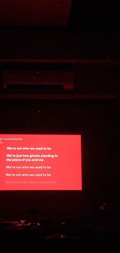 a red screen in the dark with a message on it that reads, we're not who you want to be