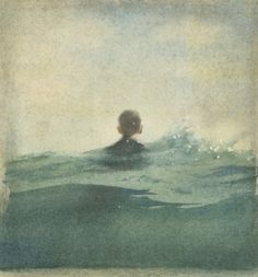 an image of a man swimming in the ocean with his head above the water's surface