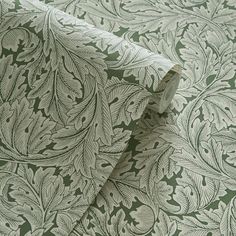 a green and white wallpaper with leaves on it's side, as well as an intricate design