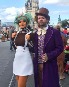 a man and woman dressed up in costumes standing next to each other on the street