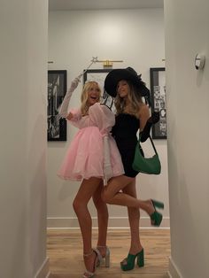 two women in dresses and hats posing for the camera