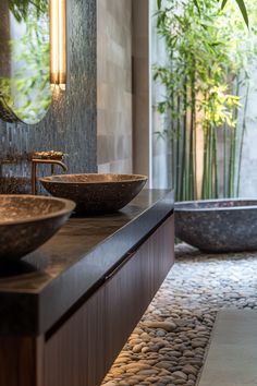 two bowls are sitting on the counter in front of a bathtub and bamboo trees