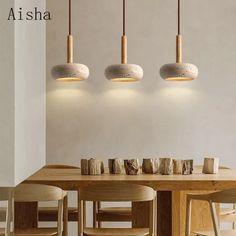 a dining room table with four lights hanging above it