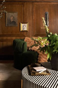 a living room filled with furniture and a green chair next to a plant on top of a table