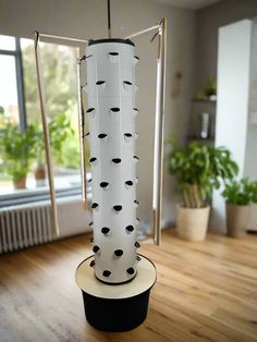 a white and black object sitting on top of a wooden floor next to a window