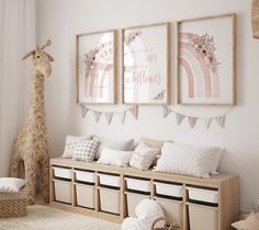 a child's room decorated in pink and white with giraffes hanging on the wall