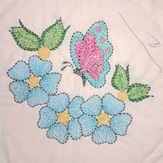 a white shirt with blue flowers and a pink butterfly on it's back side