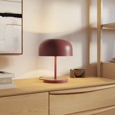 a lamp is sitting on top of a dresser next to a bookcase and books