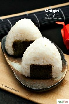 two pieces of sushi on a plate with chopsticks