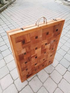 a large wooden box sitting on top of a brick floor next to a sidewalk and building