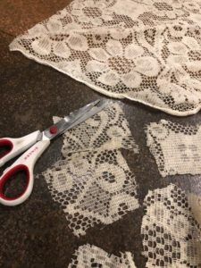 two pairs of scissors sitting on top of a piece of lace next to some crocheted doily