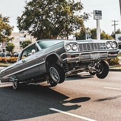 an old car is driving down the street