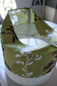 a green and white flowered hat sitting on top of a table next to a window