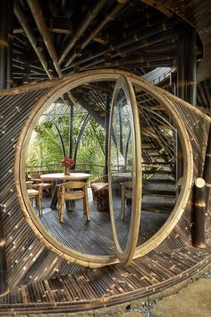 a circular mirror reflecting the inside of a room with wooden furniture and plants on it