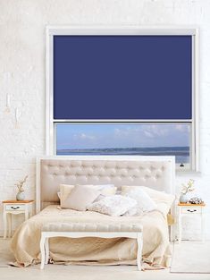 a white bed sitting under a blue window