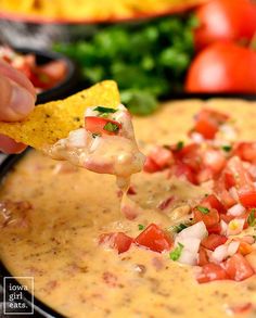 a tortilla chip being dipped with salsa