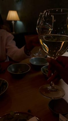 two people sitting at a table with wine glasses