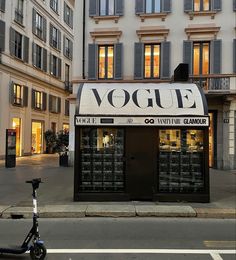 a scooter is parked in front of a store called voggie on the street