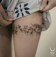 a woman is showing off her thigh with flowers on it and the bottom part of her leg