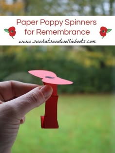 a hand holding up a paper poppy spinner for remembrances with text overlay that reads, paper poppy spinners for remembrance