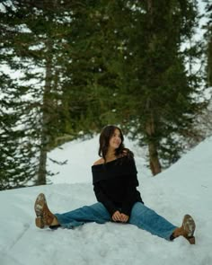 a woman sitting in the snow with her legs crossed