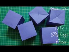 four origami cubes sitting on top of a cutting board with the words diy pop - up cubes