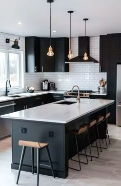 a large kitchen with black cabinets and white counter tops, an island in the middle is surrounded by bar stools