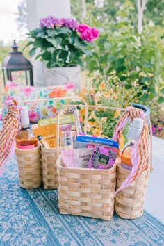 baskets filled with books sitting on top of a blue and white cloth covered picnic table