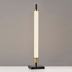 a black and gold lamp sitting on top of a white table