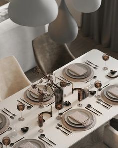 the table is set with plates, silverware and candlesticks for an elegant dinner