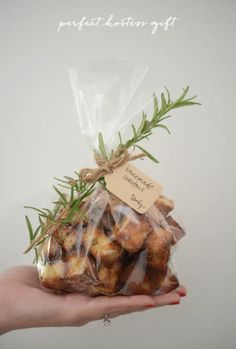 a hand holding a bag of cookies with rosemary sprigs on it and a label that says, perfect selection gift