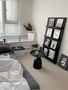 a bed room with a neatly made bed and a book shelf next to the window