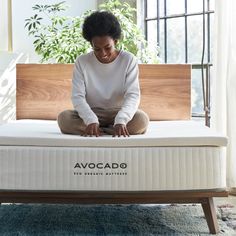 a woman is sitting on an avocado mattress