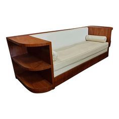 a wooden couch with a white sheet on it's back and shelf in the middle