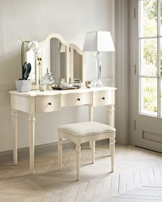 a white dressing table with mirror and stool