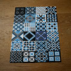 a wooden table topped with lots of blue and black squares