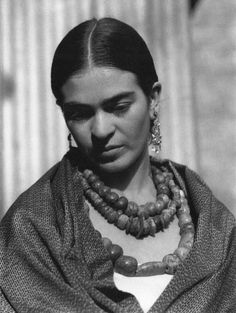 an old black and white photo of a woman with beads on her neck, wearing a shawl