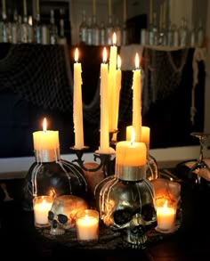 a table topped with lots of candles and skulls