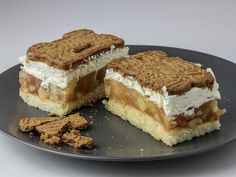 two pieces of dessert sitting on top of a black plate next to some crackers