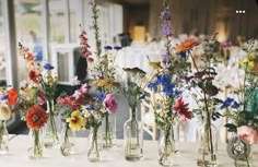 there are many vases with flowers in them on the table