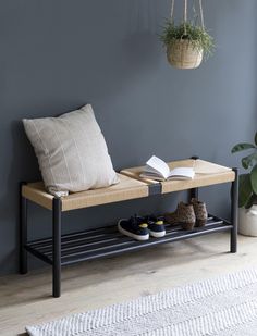 a pair of shoes sitting on top of a wooden bench next to a potted plant