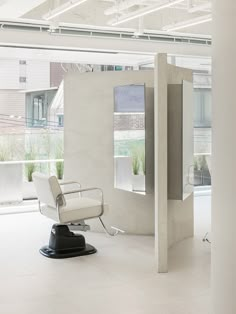 a white chair sitting on top of a hard wood floor next to a tall wall