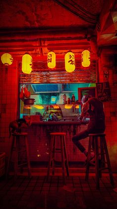 two people sitting at a bar in front of lanterns hanging from the ceiling and on stools