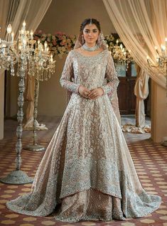 a woman in a wedding dress standing next to a chandelier