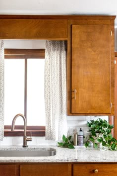 a kitchen with wooden cabinets and marble counter tops